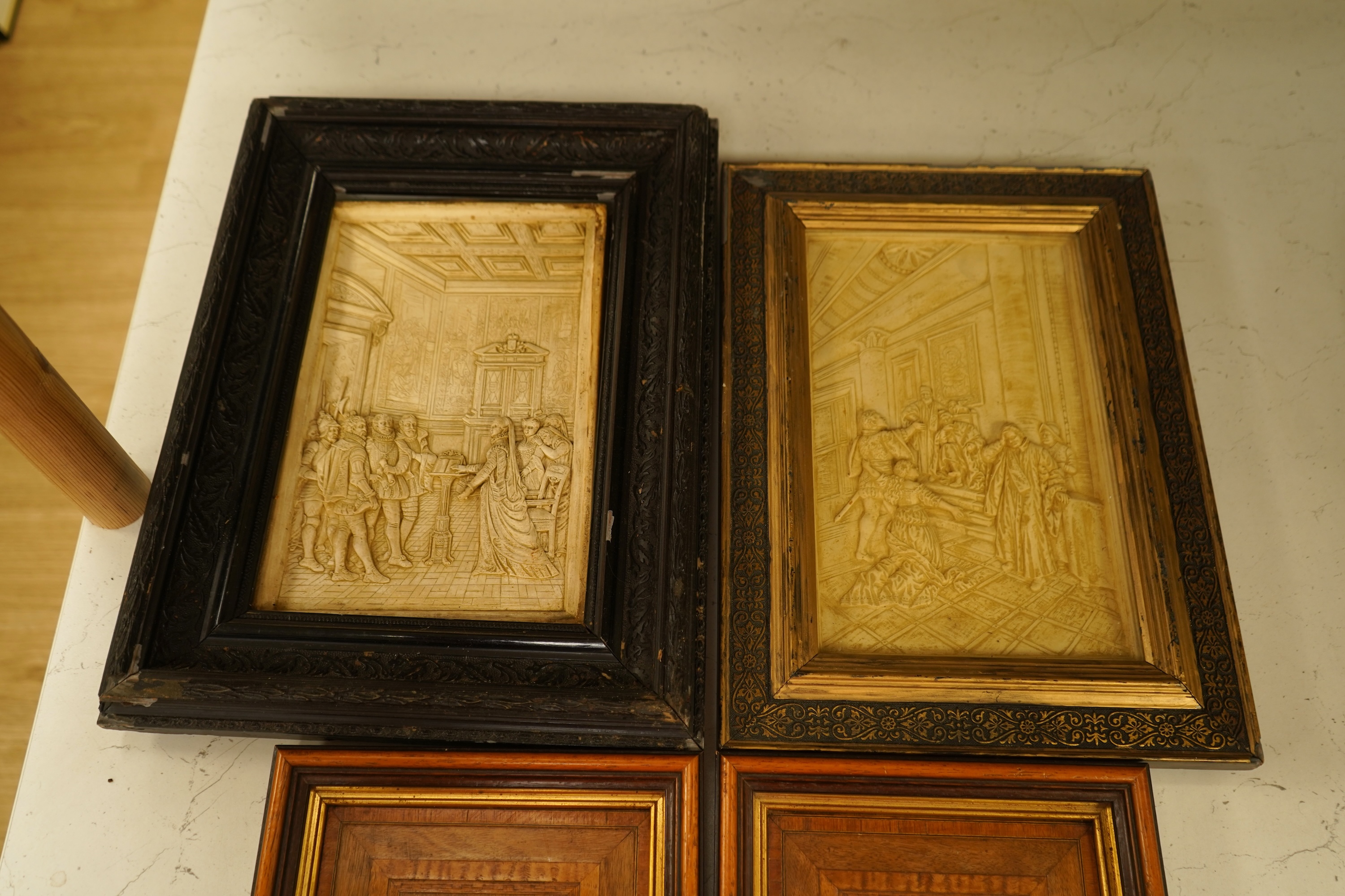 SVD., a pair of marquetry and penwork butterfly panels and a pair of relief moulded plaster panels depicting Tudor scenes, each framed, largest 41cm high
